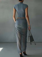Complete with a short-sleeved blue t-shirt and a draped sheer mesh skirt