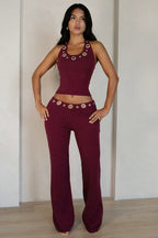 Conjunto compuesto por un top con escote halter y aberturas y unos pantalones rectos de corte ajustado