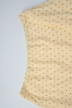 Conjunto de falda asimétrica con cuello drapeado y lunares amarillos